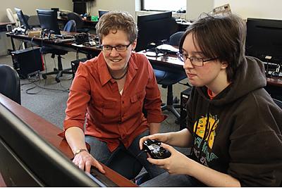 Student and professor in computer lab with game controller and keyboard